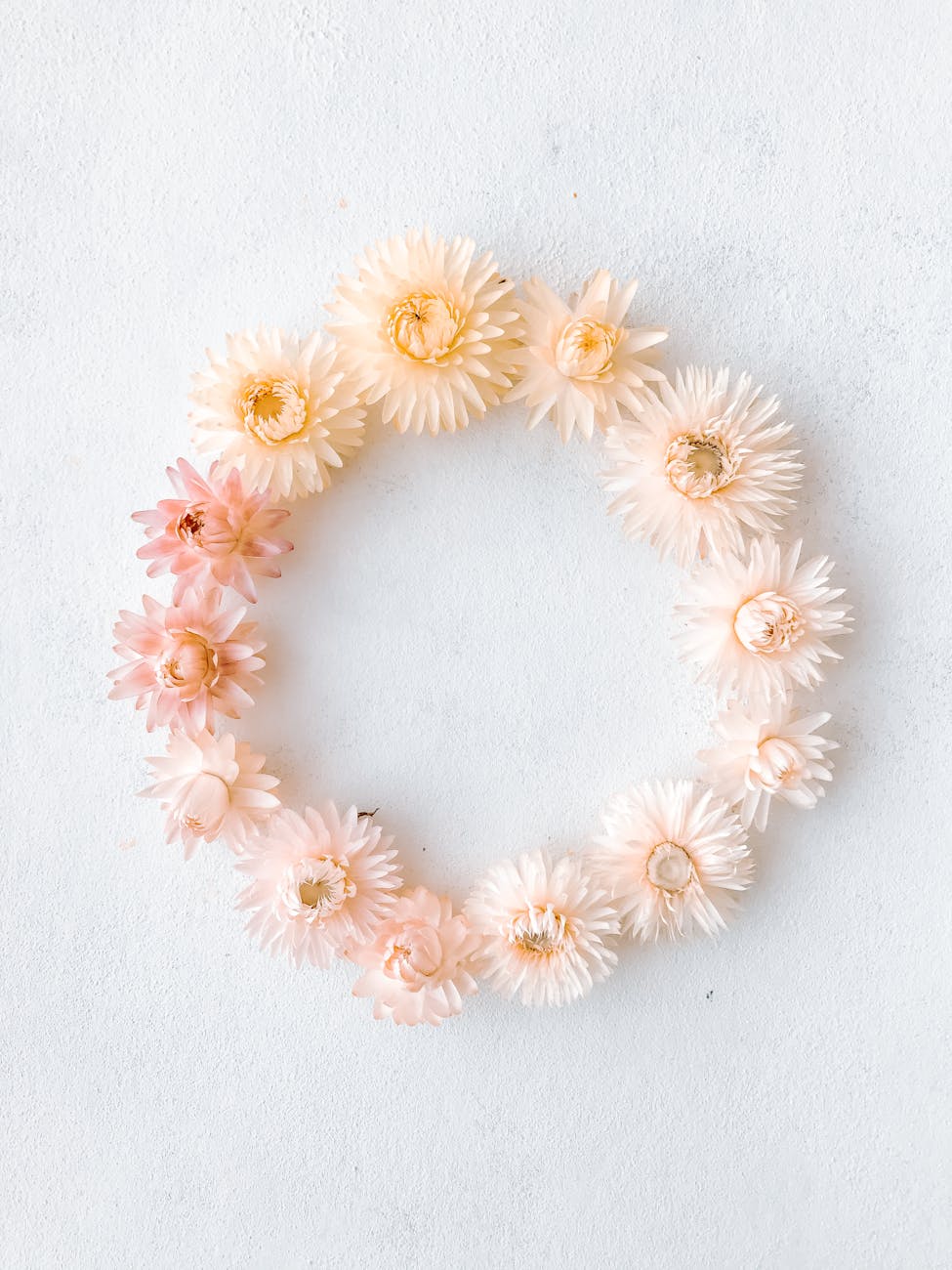 white and yellow flower wreath on white surface